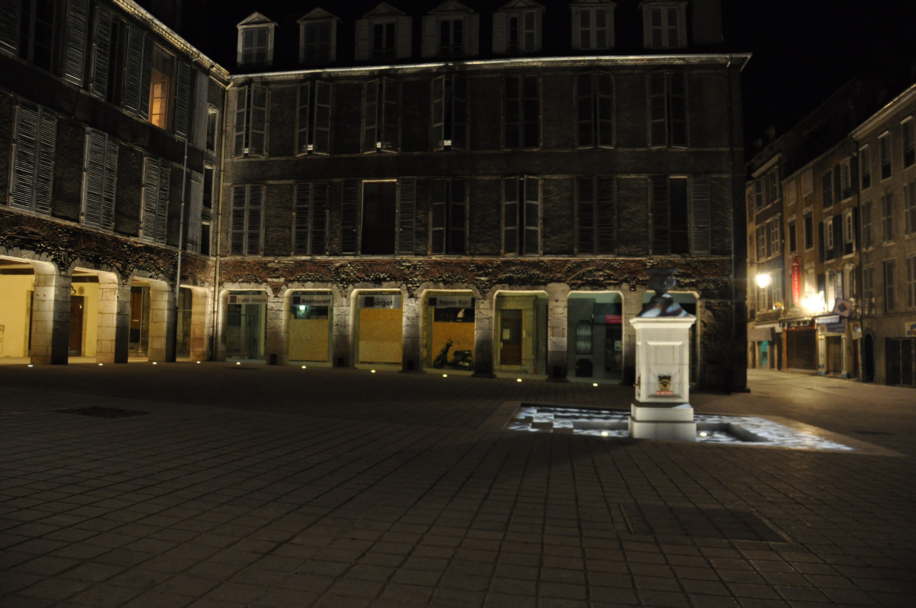 Les éclairages fonctionnels sont issus de lanternes sur console courte en façade tandis que les arcades de la place de la Reine Marguerite sont éclairées d’une lumière blanche.