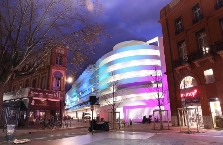 batiment éclairé la nuit avec un effet d'aurores boréales