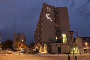 Vue d'une façade d'imeuble de nuit avec une projection d'image lumineuse à Ramonville