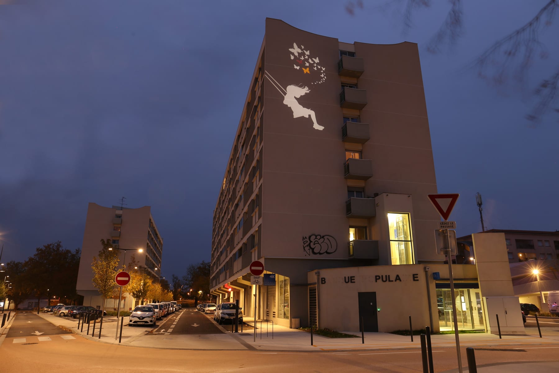 Vue d'une façade d'imeuble de nuit avec une projection d'image lumineuse