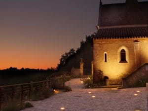 coucher de soleil a bonaguil avec chapelle éclairée en premier plan