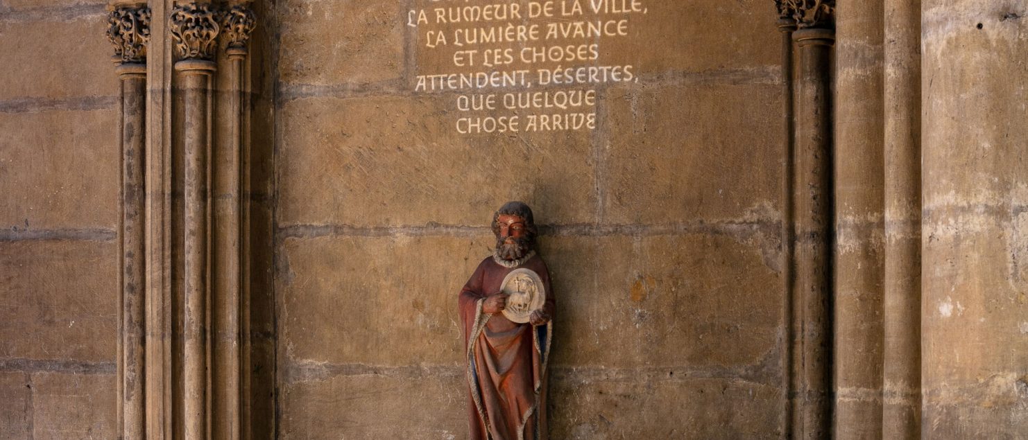 statue dans eglise avec projection de texte lumière