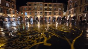 place éclairée avec projections d'image gobo sur miroir d'eau