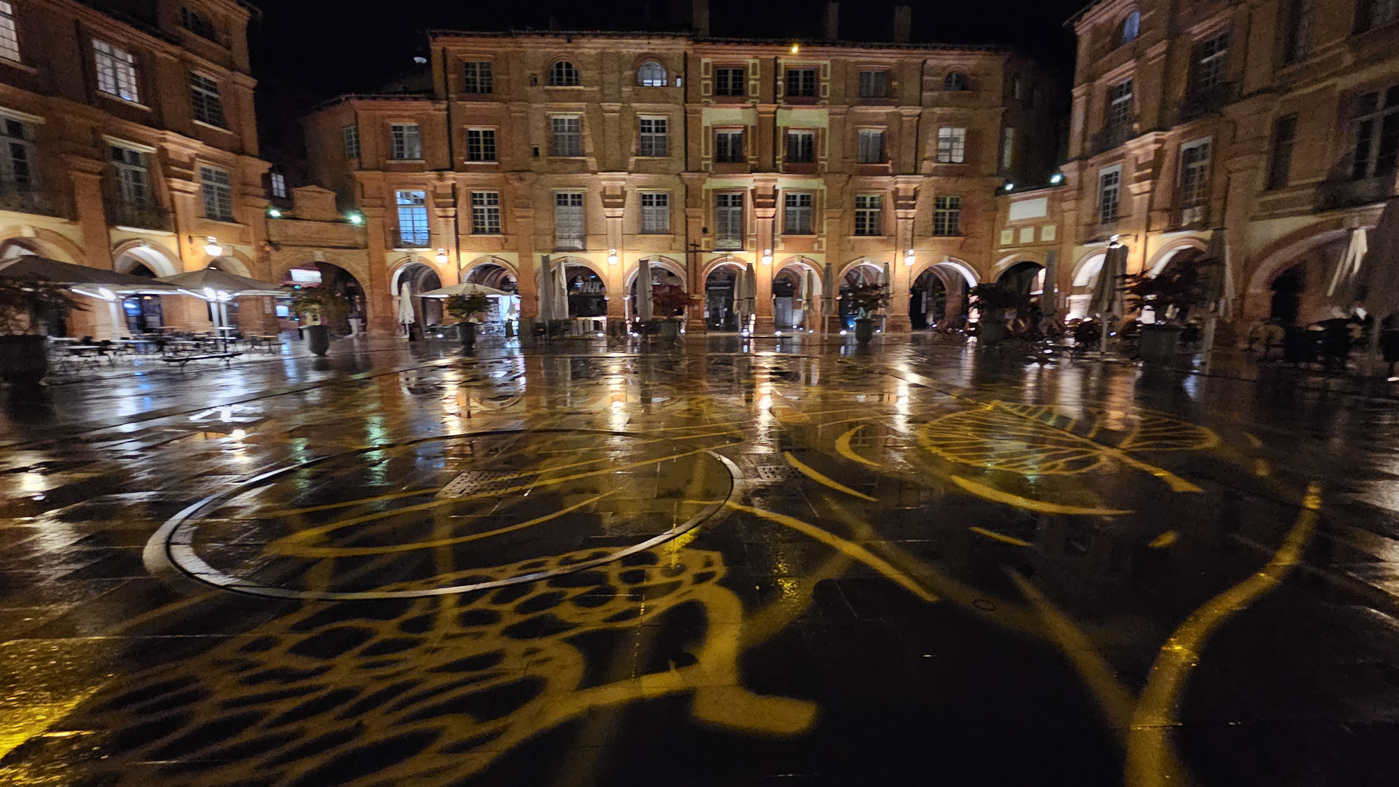 place éclairée avec projections d'image gobo sur miroir d'eau