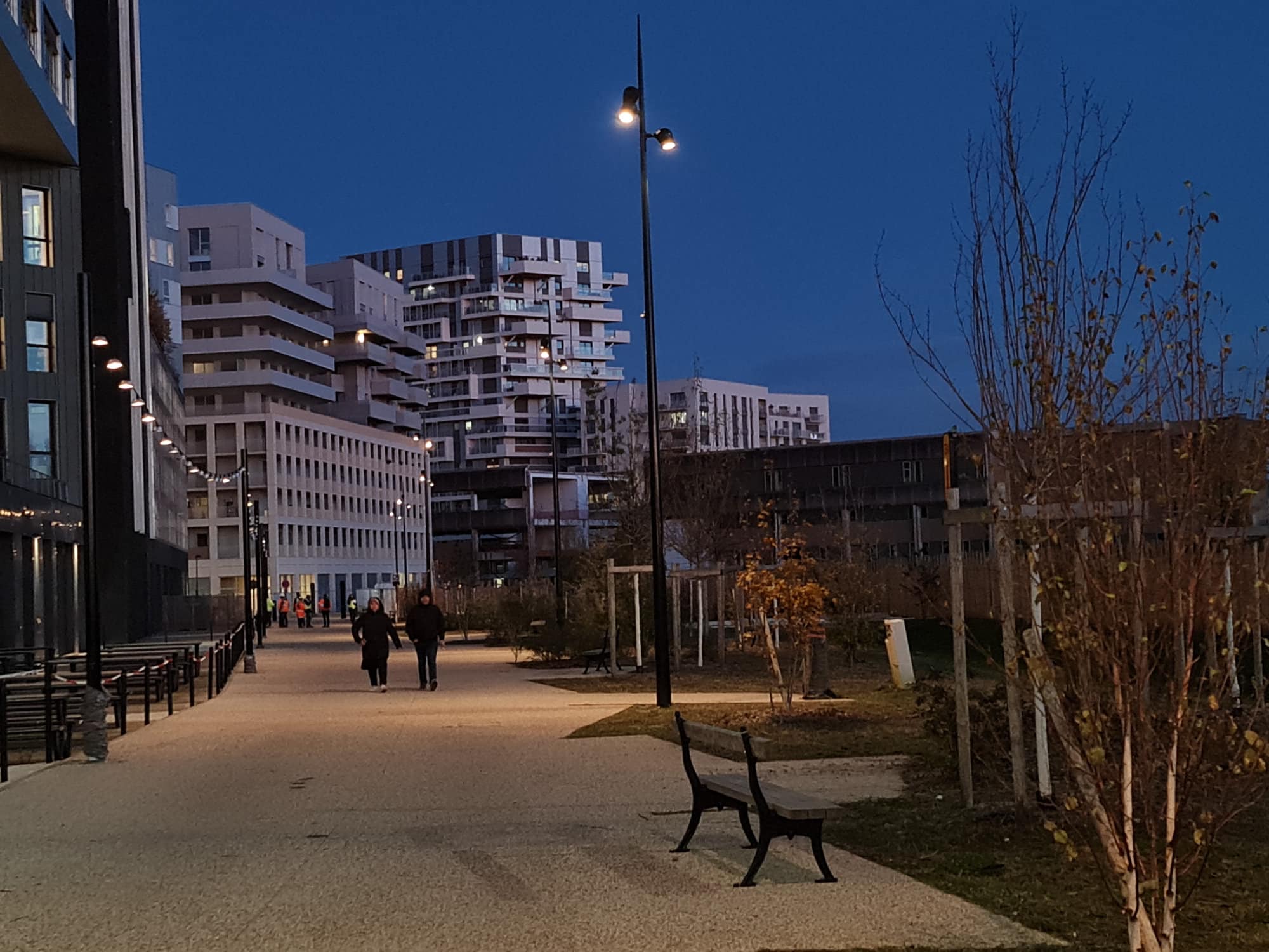 aménagement urbain nocturne avec mâts aiguilles et guirlandes