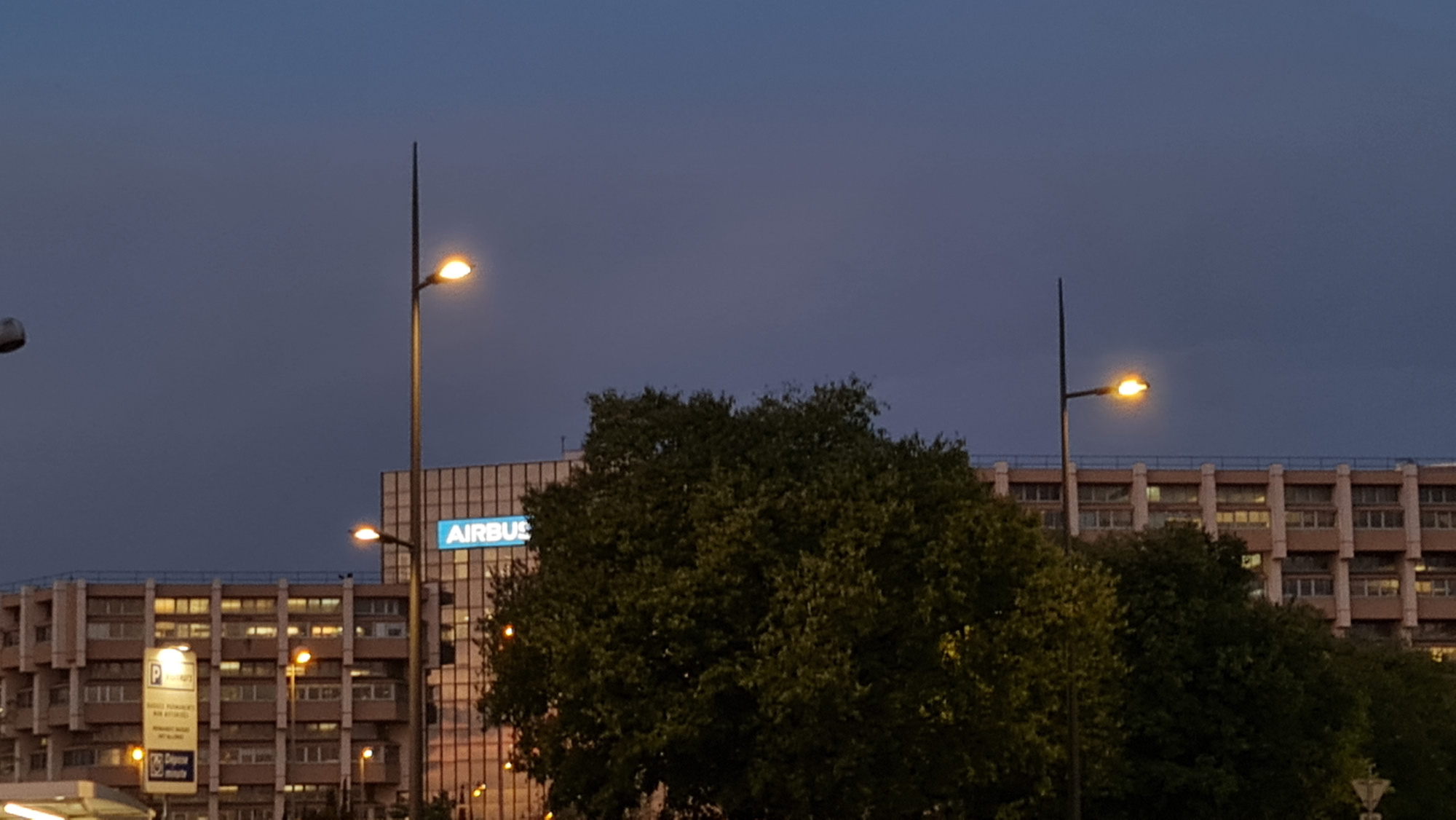 mâts d'éclairage et bâtiment d'airbus en arrière plan