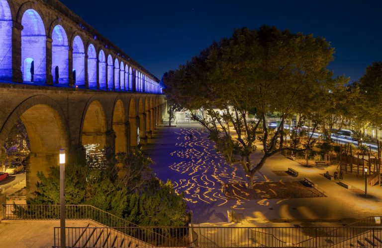 vue de nuit de la nouvelle place Max Rouquette avec des éclairages couleur ambre et bleu