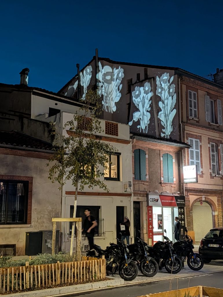 projection d'image avec des fleurs sur une façade en centre ville