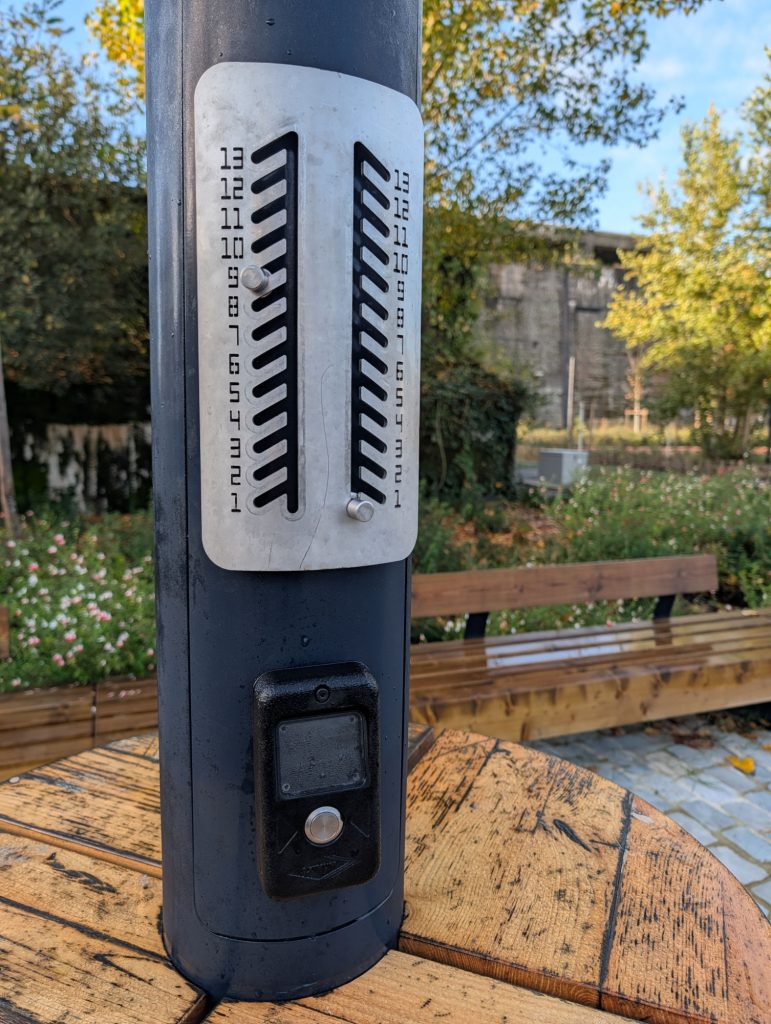 compteur de points de pétanques sur un mat d'éclairage public avec bouton poussoir pour l'allumage du mât et tablette en bois