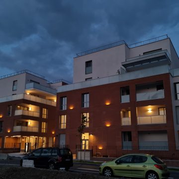 façade en brique éclairée de la résidence ariane à Toulouse