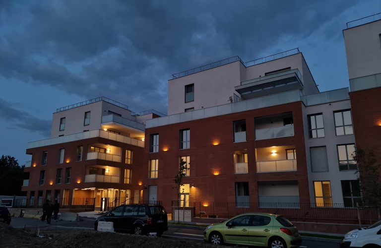 façade en brique éclairée de la résidence ariane à Toulouse